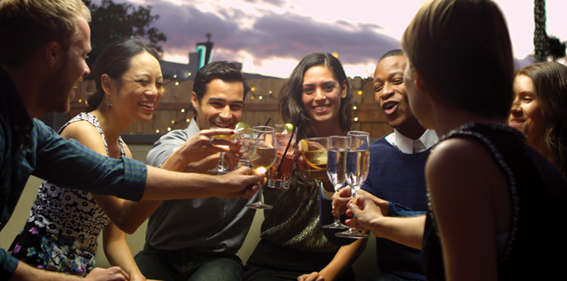 2023_IW_Web_art-Finals6 A group of people toasting with wine glasses.